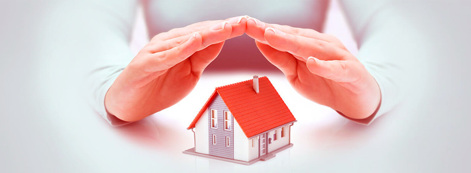 Hands sheltering a model house